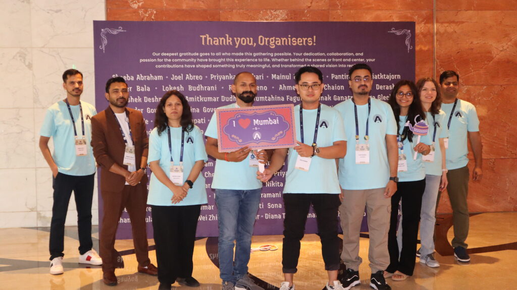 Rolly Bueno standing with fellow WordCamp Asia 2026 organizers in front of a “Thank you, Organisers!” backdrop, with one person holding an “I love Mumbai” sign.